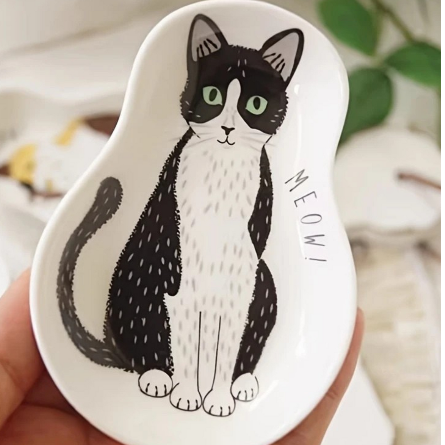 Ceramic spoon rest with black and white at design. "Meow!" written on it.